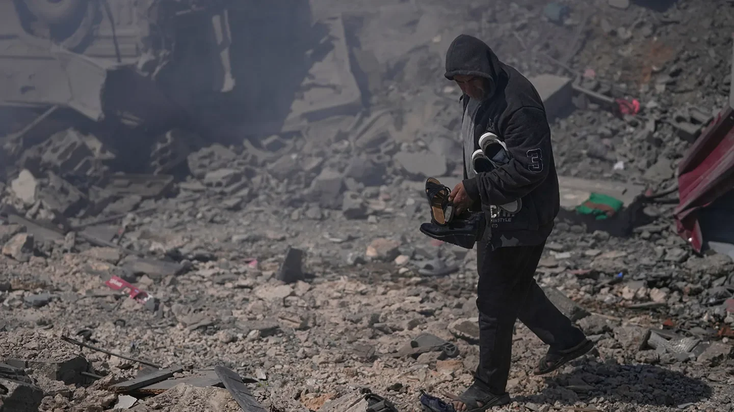 A man carries shoes from his destroyed house that was hit by Israeli airstrikes hit several houses in Sir al-Gharbiyeh village south Lebanon, Sunday, March, 8, 2026. (Mohammed Zaatari/AP Photo)