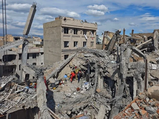Rescue workers search for bodies in the rubble of a residential building following a hit in an airstrike in the early hours of March 27, 2026 in Tehran, Iran. (Photo by Majid Saeedi/Getty Images) Majid Saeedi via Getty Images