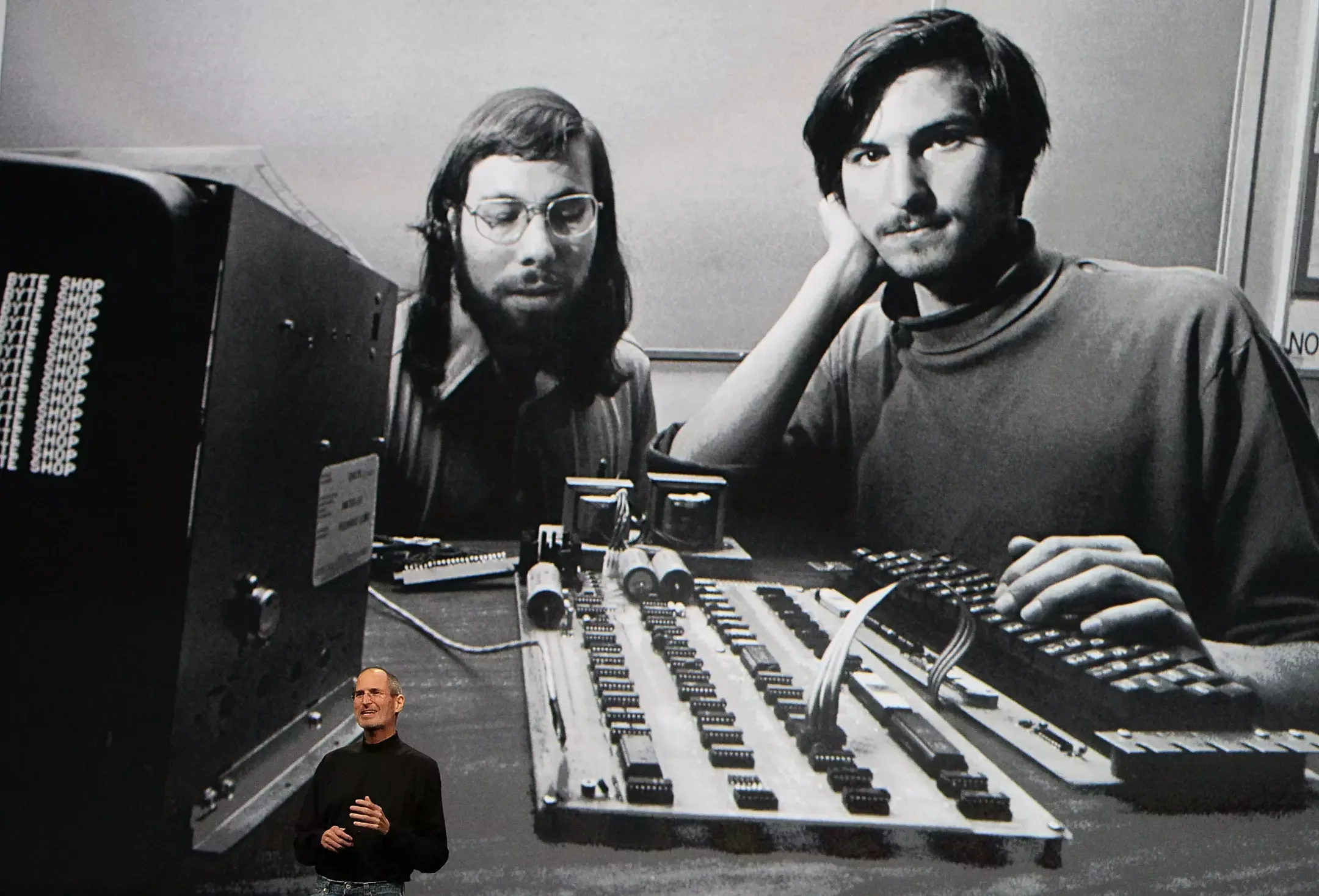 Apple Inc.’s then-CEO Steve Jobs speaks in front of an early image of himself and Steve Wozniak during an Apple event on Jan. 27, 2010, in San Francisco. (Justin Sullivan / Getty Images)