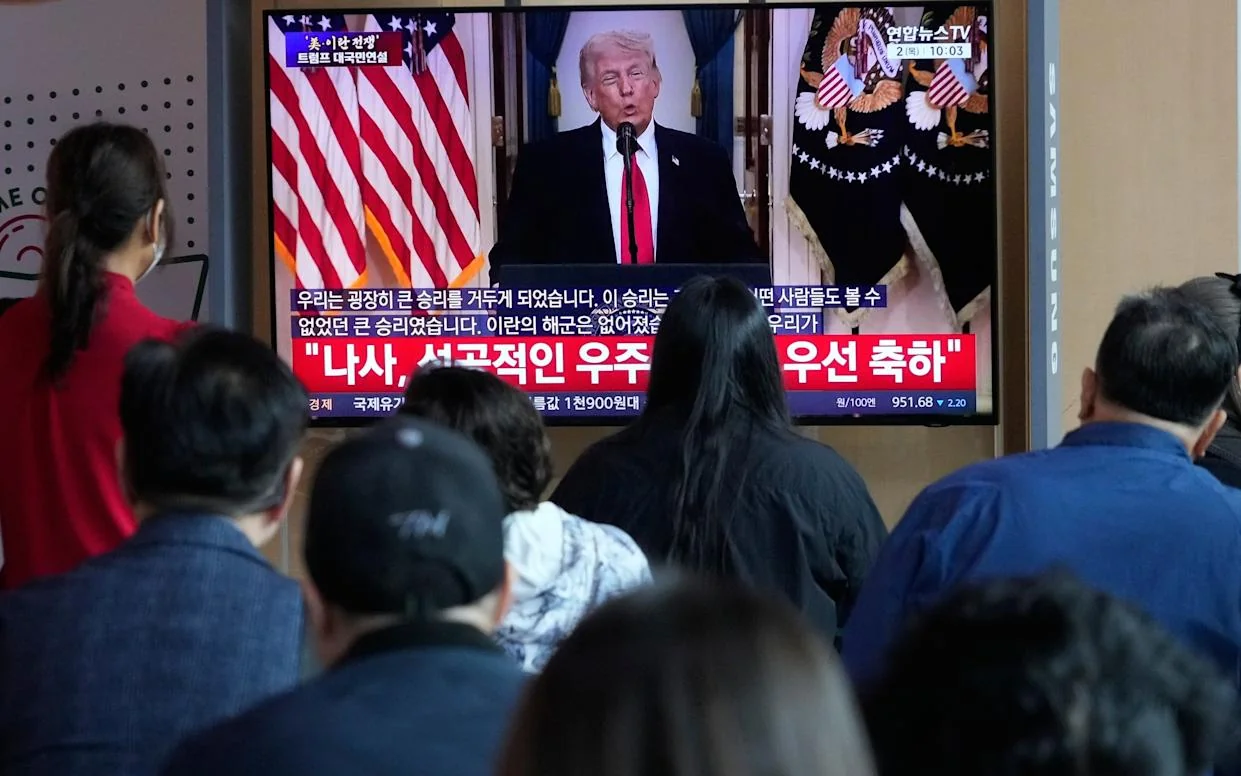 People in South Korea watch Mr Trump’s speech. Asian markets fell after his address - AP