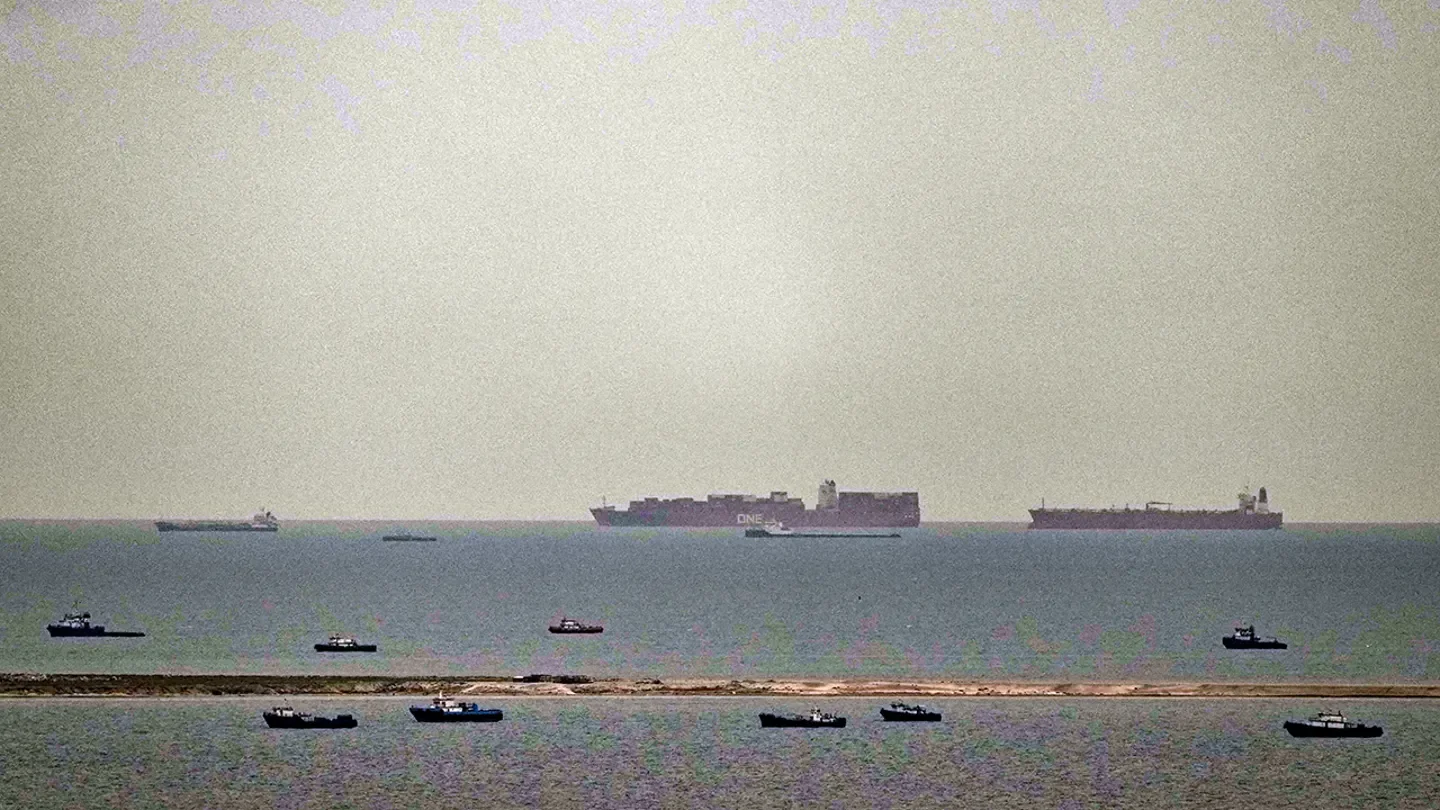 Fishing boats dot the sea as cargo ships, in the background, sail through the Arabian Gulf toward the Strait of Hormuz off the United Arab Emirates, Friday, March 27, 2026. (AP Photo)