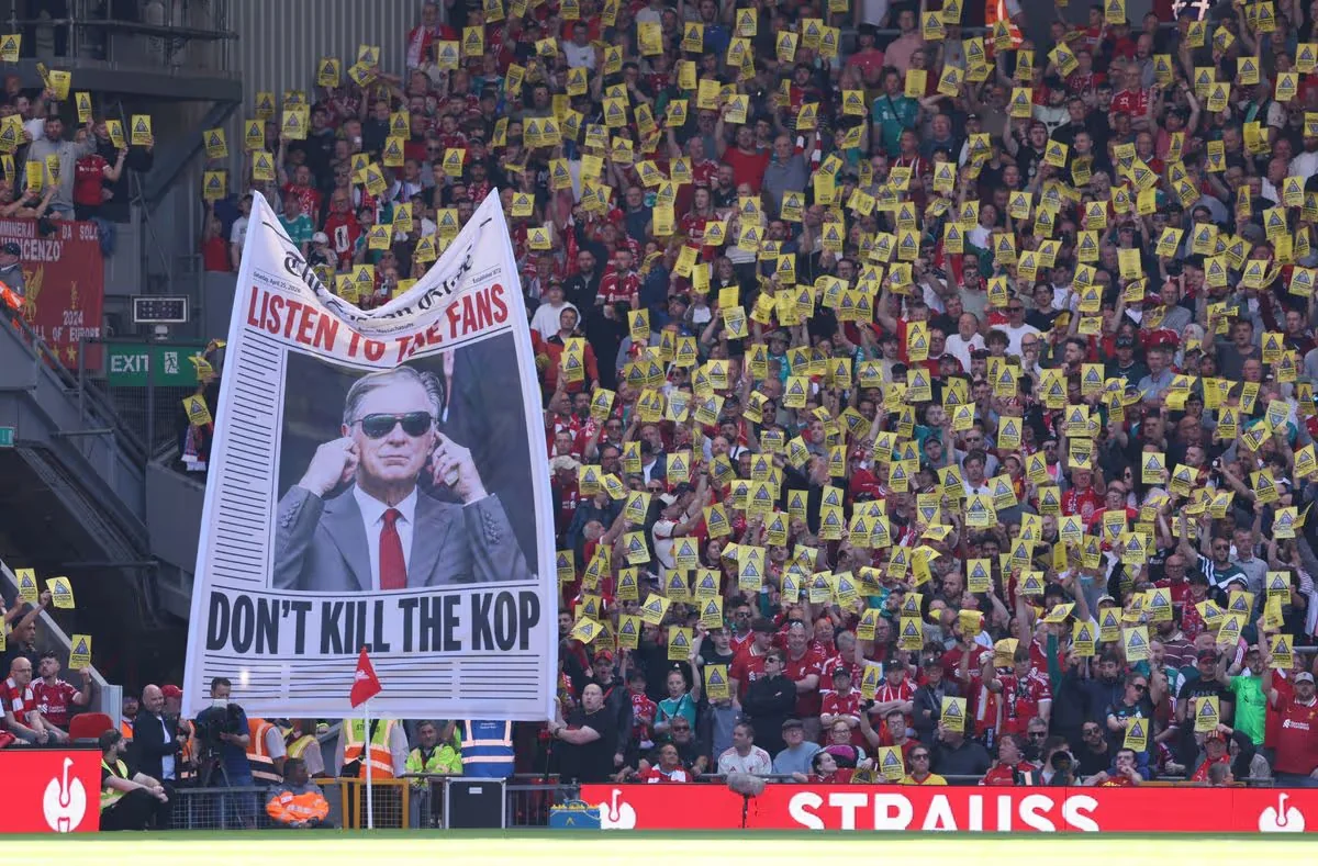 Fans of Liverpool protest rising ticket prices with posters that read 'Caution, Anfield's soul at risk'