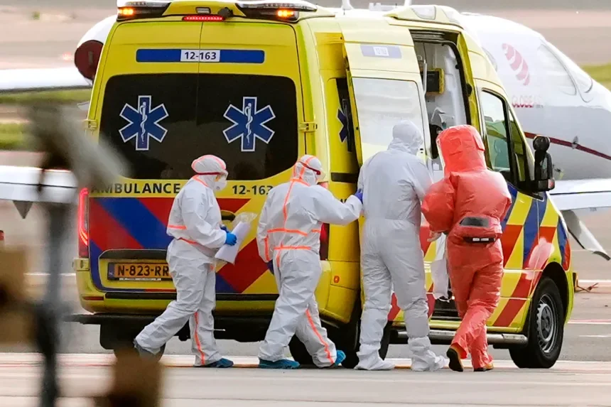 Medics escort a patient, second right, evacuated from the MV Hondius cruise ship with suspected hantavirus infection, to an ambulance after being flown Wednesday to Schiphol airport, Amsterdam, Netherlands. Peter Dejong/AP
