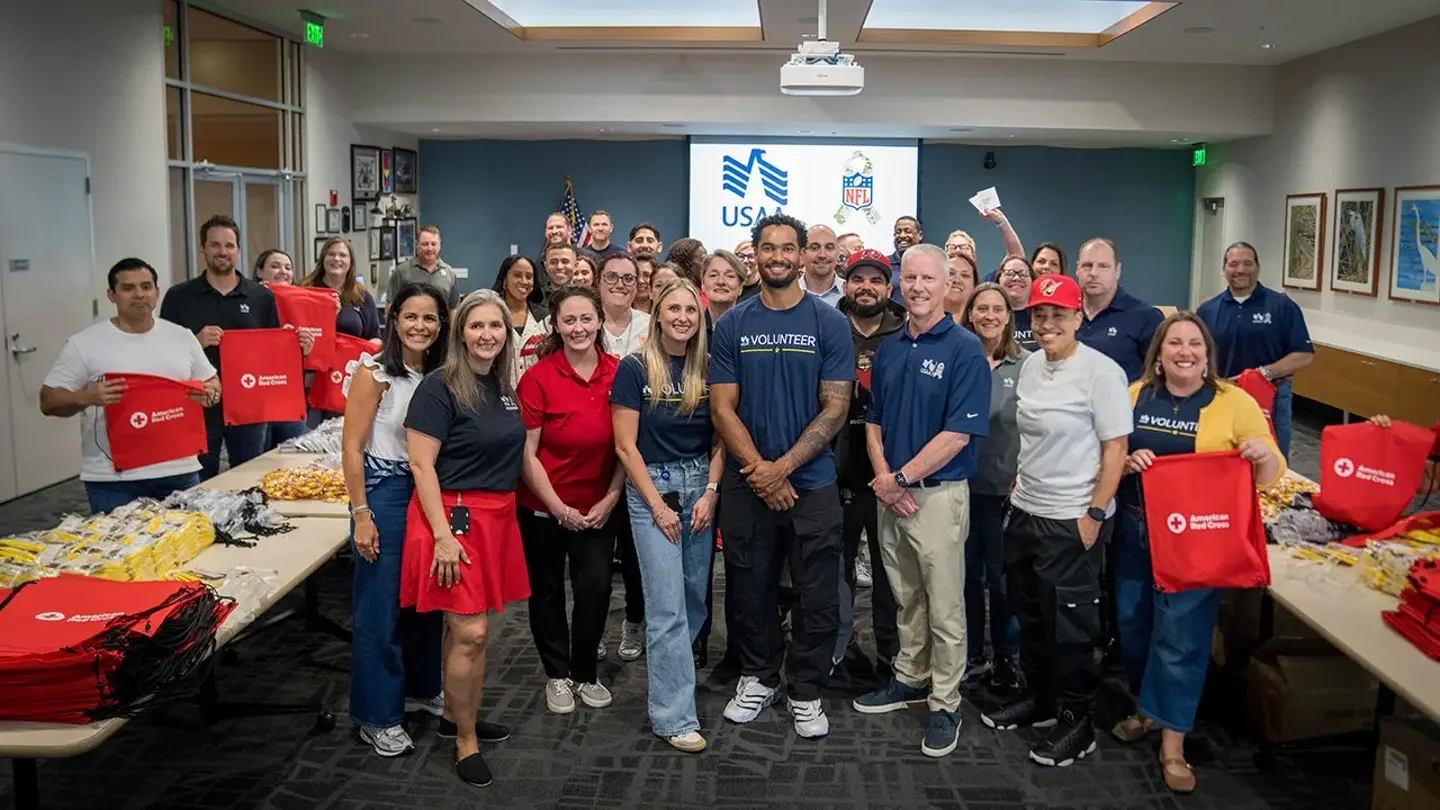 Tampa Bay Buccaneers wide receiver Emeka Egbuka, surrounded by USAA volunteers, creating hurricane disaster kits ahead of hurricane season in Florida. (USAA)
